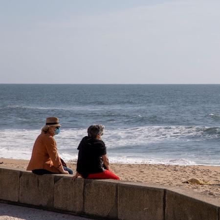 7.mai.2020 - De máscara, pessoas observam o mar em praia de Espinho, em Portugal, então fechada para banhistas - Rita Franca/SOPA Images/LightRocket via Getty Images