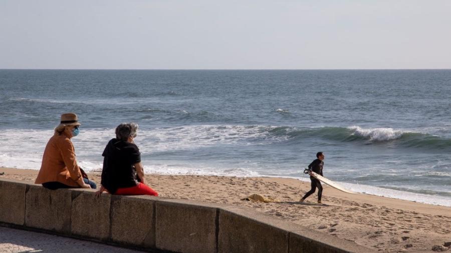 7.mai.2020 - De máscara, pessoas observam o mar em praia de Espinho, em Portugal, atualmente fechada para banhistas - Rita Franca/SOPA Images/LightRocket via Getty Images