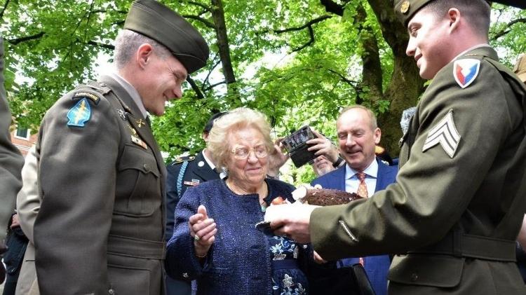 Sergeant Wallis (right) and Colonel Gomlak (left) deliver a cake to Meri Mion - US Army - US Army