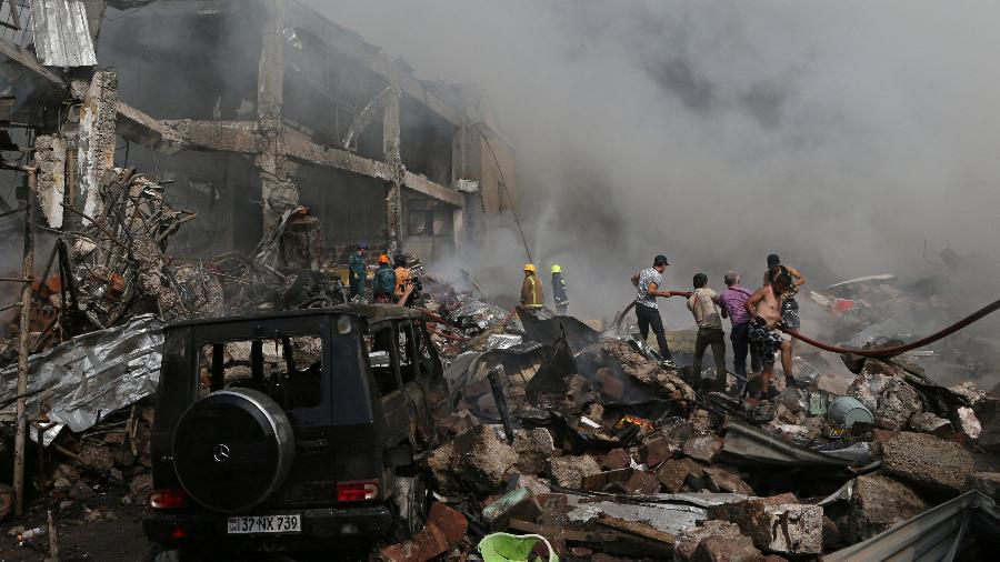Pessoas ajudam bombeiros a extinguir fogo depois de explosão na Armênia - PHOTOLURE/via REUTERS