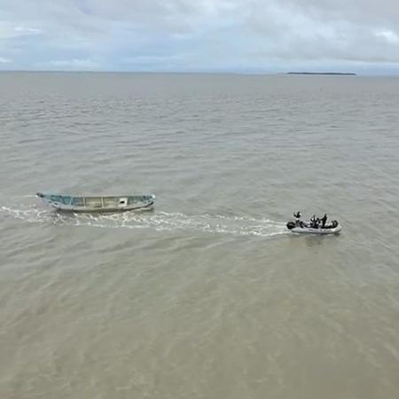Barco sendo levado por outro para corpos serem periciados no Pará