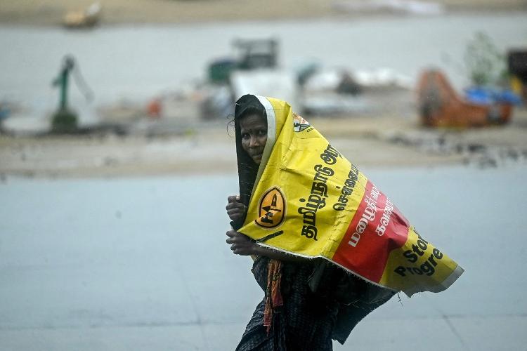 Mulher se protege da chuva em Chennai, na Índia