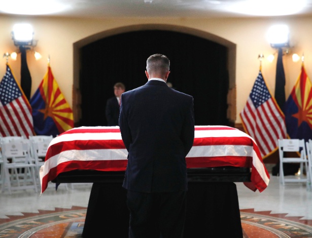 Convidado presta suas homenagens em frente ao caixão do senador John McCain durante seu serviço memorial no Capitólio do Arizona, em Phoenix - Jae C. Hong/Pool via The New York Times