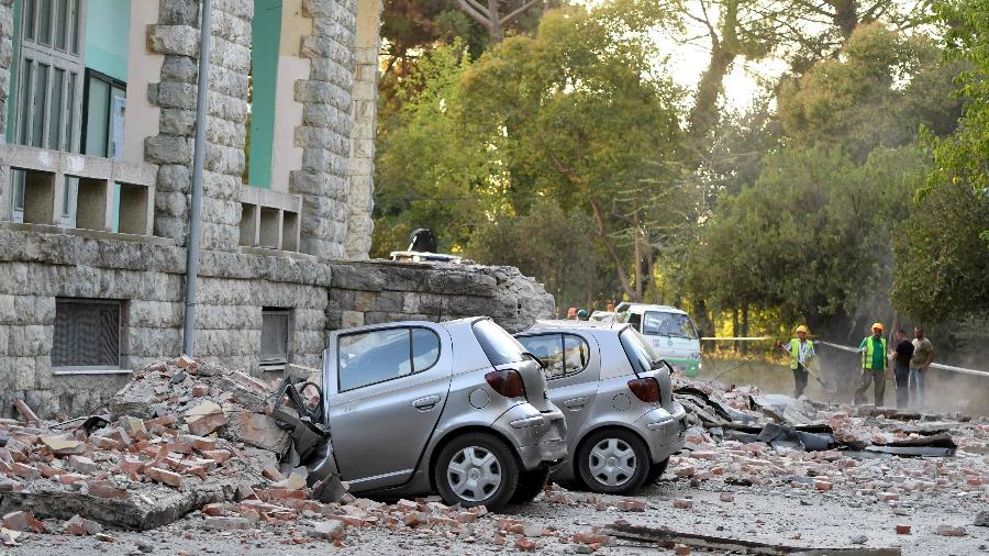 Carros esmagados por escombros na cidade de Tirana, na Albânia - GENT SHKULLAKU / AFP