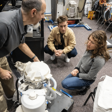 Christina Koch, especialista da missão Artemis II (à direita), durante a ativação do sistema de banheiro da espaçonave Orion antes do lançamento