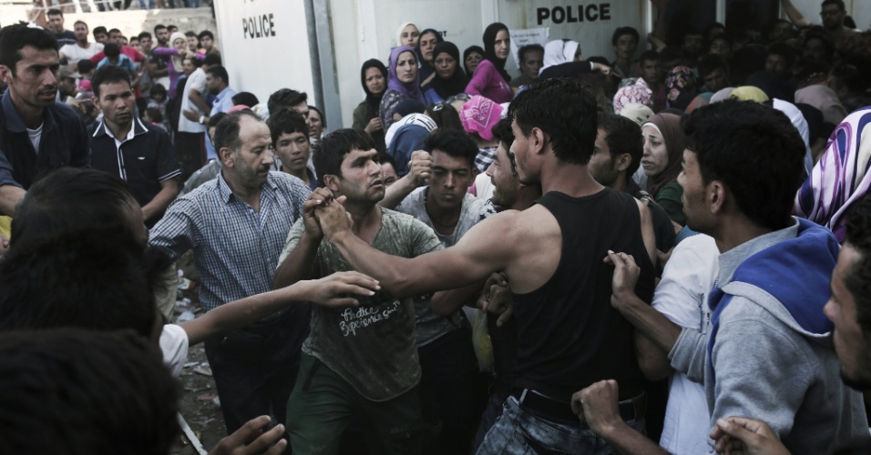 6.set.2015 - Afegãos e sírios brigam por prioridade na fila de registro no porto de Mytilene, na ilha grega de Lebos, no mar Egeu. Mais de 230 mil refugiados e imigrantes chegaram à Grécia pelo mar este ano