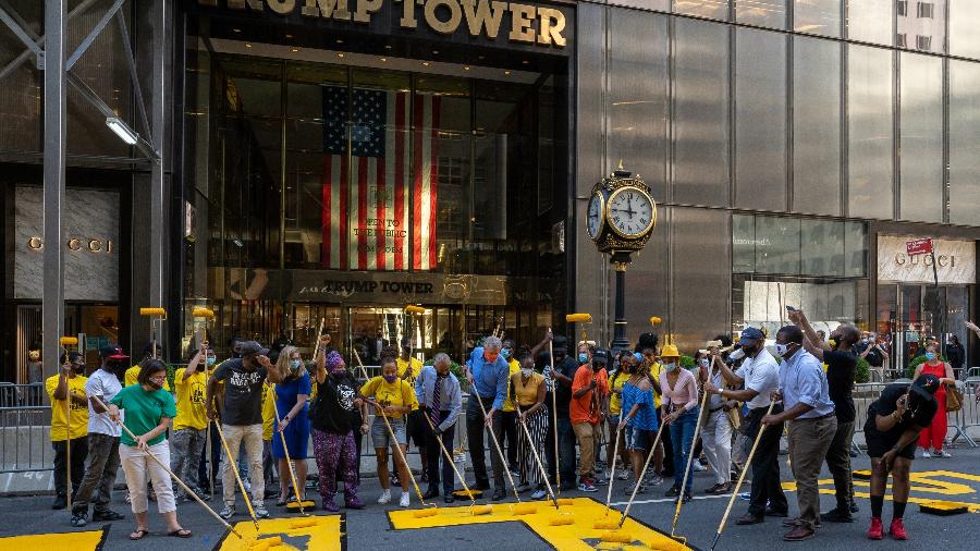 O prefeito de Nova York, Bill De Blasio (ao centro, de camisa azul), participa de mutirão na principal avenida da cidade - Getty Images