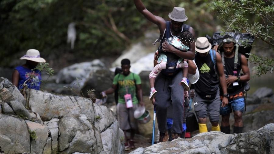 26.set.2021 - Migrantes haitianos atravessam a floresta Darien, entre Colômbia e Panamá, com crianças - Raul ARBOLEDA / AFP