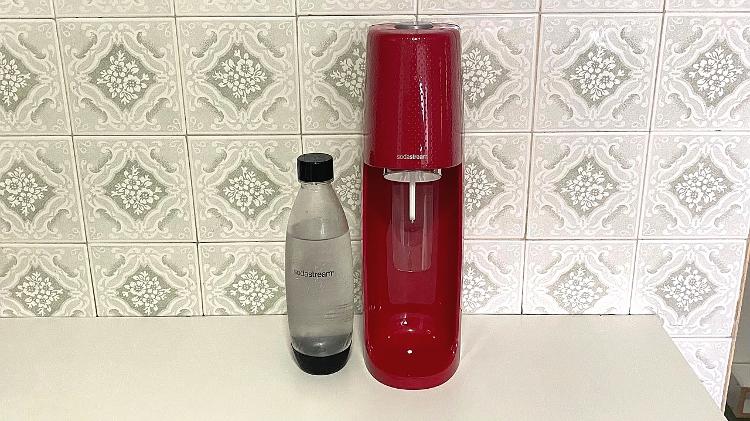 O kit para fazer água com gás em casa vem com uma máquina, uma garrafa plástica e um cilindro de dióxido de carbono