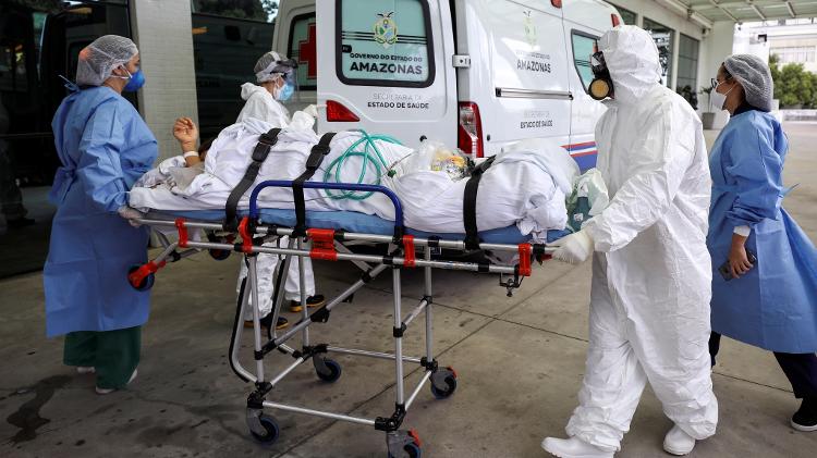 Funcionários de hospital transportam paciente com covid-19 durante pico da pandemia, em Manaus