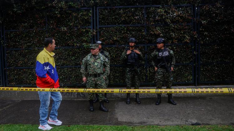 Soldados fazem segurança enquanto venezuelanos chegam para votar no dia da eleição presidencial venezuelana, em um local de votação no Colégio Técnico Palermo, em Bogotá, Colômbia