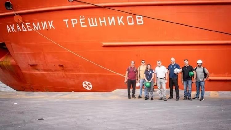 Equipe da UFMG, UnB e UFV em frente ao navio quebra-gelo científico Akademik Tryoshnikov