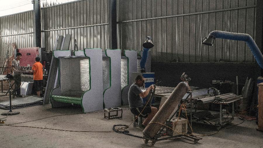 Trabalhadores em linha de produção de uma fábrica de refrigeradores em Xingfu, na China - Gilles Sabrie/The New York Times