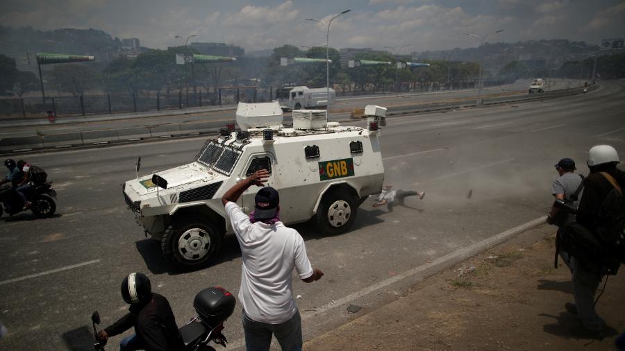 30.abr.2019 - Um apoiador dos opositores de Nicolás Maduro é atropelado por um veículo da Guarda Nacional da Venezuela em protesto - Ueslei Marcelino/Reuters