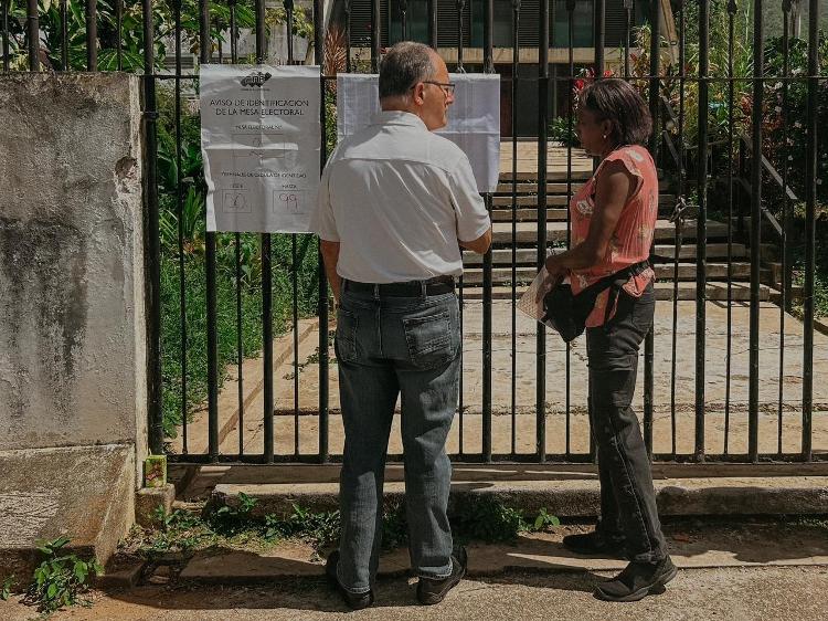 Casal olha local de votação em eleições presidenciais na Venezuela