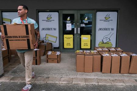 Cédulas embaladas e das máquinas de leitura de cédulas na sede da Comissão Eleitoral de San Juan em San Juan, Porto Rico