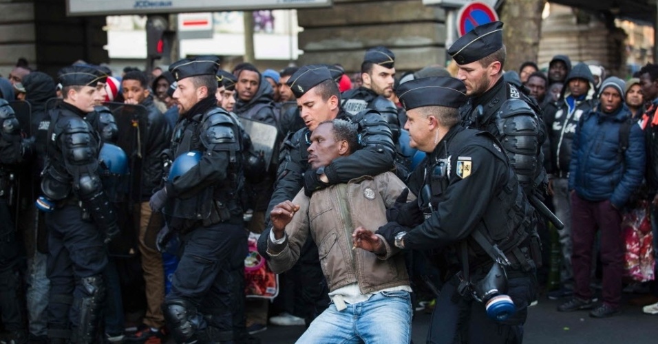 2.mai.2016 - Policiais franceses prendem um homem durante o fechamento de um acampamento improvisado sob a estação de metrô Stalingrado, em Paris, na França. Cerca de 1.615 imigrantes moravam no local. A polícia afirma que todos os moradores do acampamento foram encaminhados para abrigos