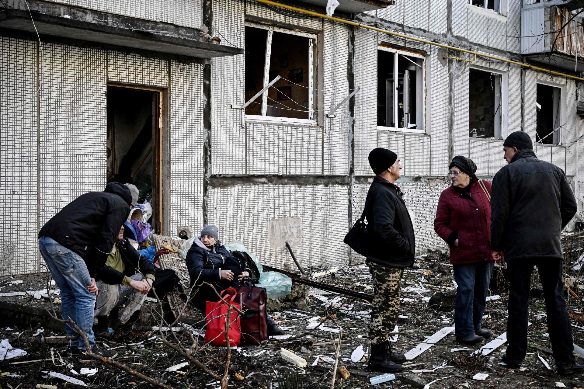 24.fev.2022 - Pessoas ficam do lado de fora de um prédio destruído após bombardeios na cidade de Chuguiv, no leste da Ucrânia - Aris Messinis/AFP