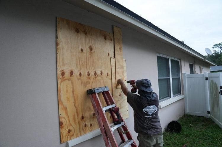 Morador fecha suas janelas com tábuas em Palm Harbor, Flórida, antes de o furacão Milton atingir a costa