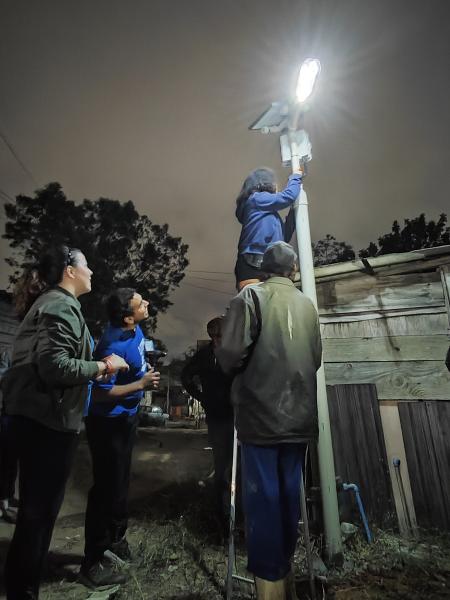 Moradores e voluntários instalam poste de energia movido a luz solar na ocupação Anchieta, na zona sul de São Paulo