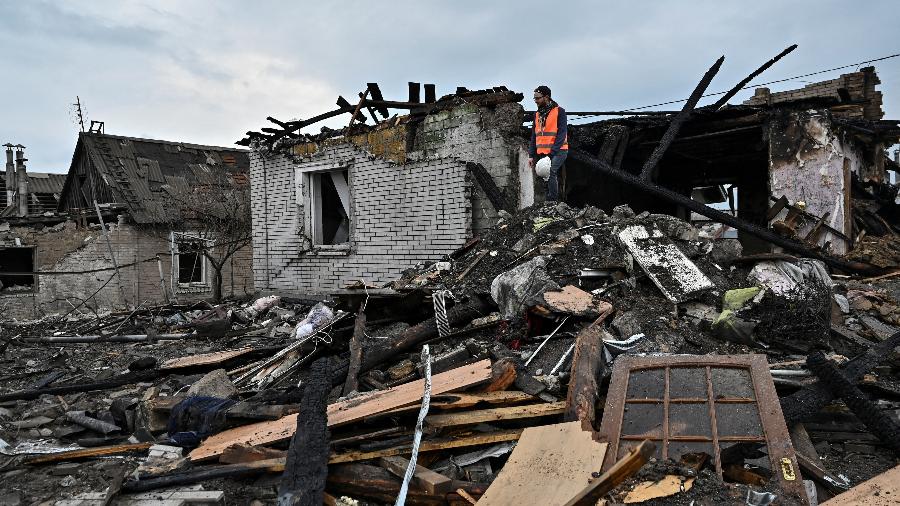 Um voluntário inspeciona os restos de uma casa atingida por um míssil russo em Zaporizhzhia, na Ucrânia - STRINGER/REUTERS