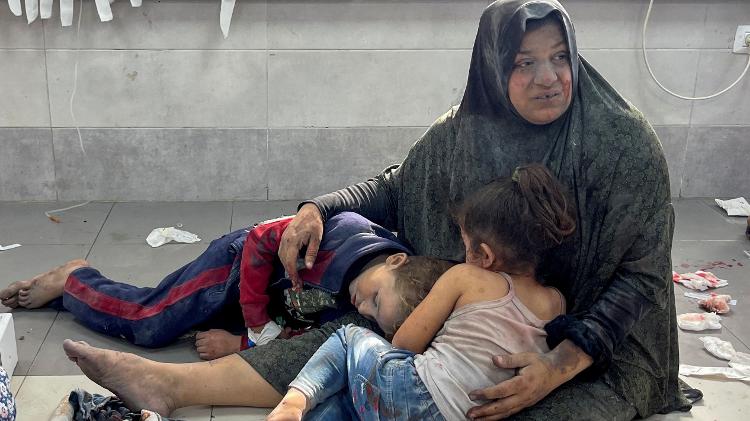 Mulher palestina com seus filhos, feridos em bombardeio, no hospital Shifa hospital na cidade de Gaza