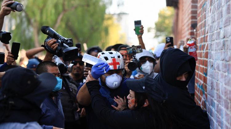 Médico observa manifestante durante protesto contra política de imigração dos Estados Unidos Médico observa manifestante durante protesto contra política de imigração dos Estados Unidos