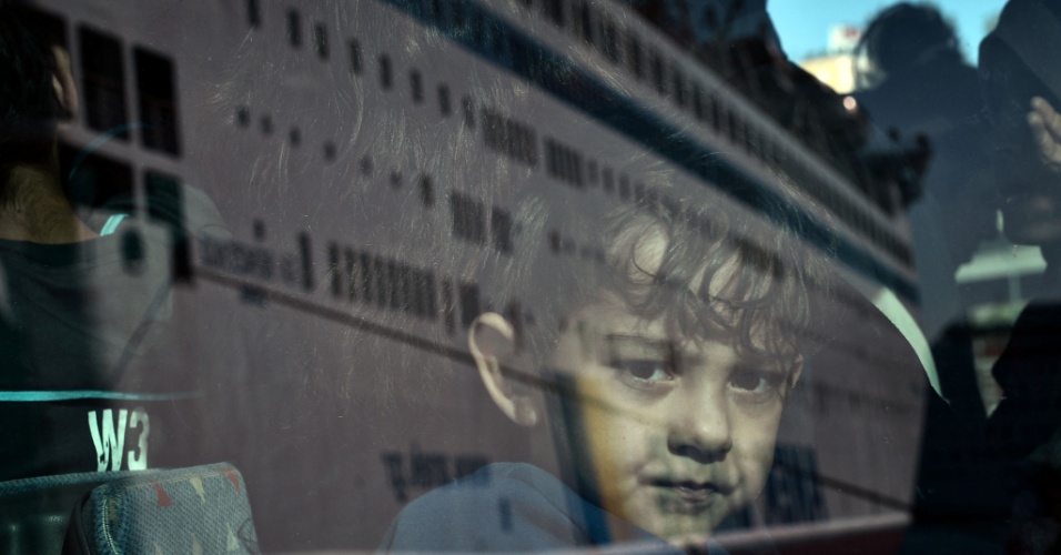 1º.out.2015 - Menino refugiado olha para fora do ônibus, após desembarcar de uma balsa no porto de Pireu, em Atenas, Grécia