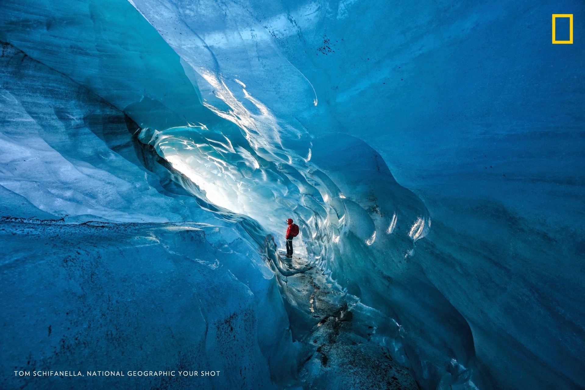 Guia na Islândia admira uma das cavernas de gelo do país. A personagem da foto entra na caverna há anos e afirma que, desde 2000, a área livre vem se expandido por causa do aquecimento global. Em menos de 15 anos, as geleiras da Islândia perderam 12% de seu tamanho - Tom Schifanella/National Geographic Your Shot