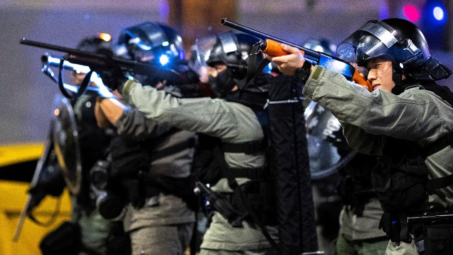 Policiais apontam armas a manifestantes contra o governo em Hong Kong - Athit Perawongmetha/Reuters