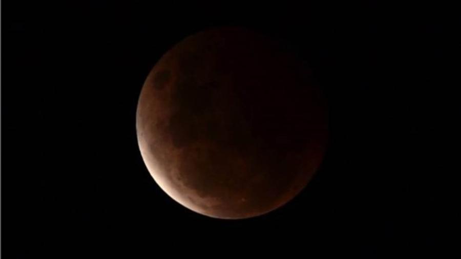 Uma rara "superlua sangue" em meio a eclipse lunar pode ser vista no céu acima de Wollongong, na Austrália, em 26 de maio - EPA/Dean Lewis