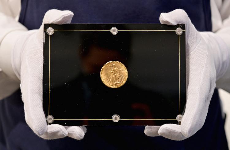 11.mar.2021 - Um funcionário da Sotheby's segura uma moeda Double Eagle de 1933 durante um leilão ao vivo; peça faz parte da última série de moedas de ouro conhecidas como 'Double Eagle' emitidas pela Casa da Moeda dos Estados Unidos