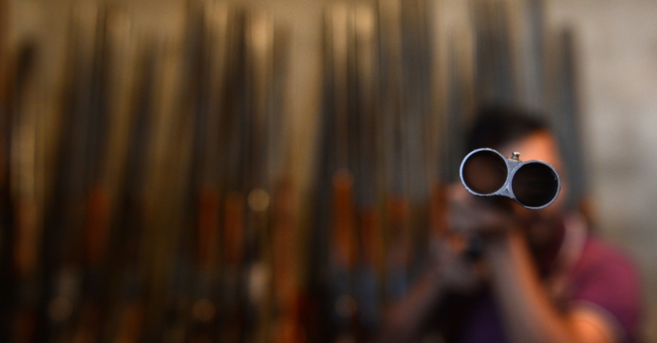1º.set.2015 - Armeiro verifica rifle dentro de uma fábrica em Srinagar, na Índia