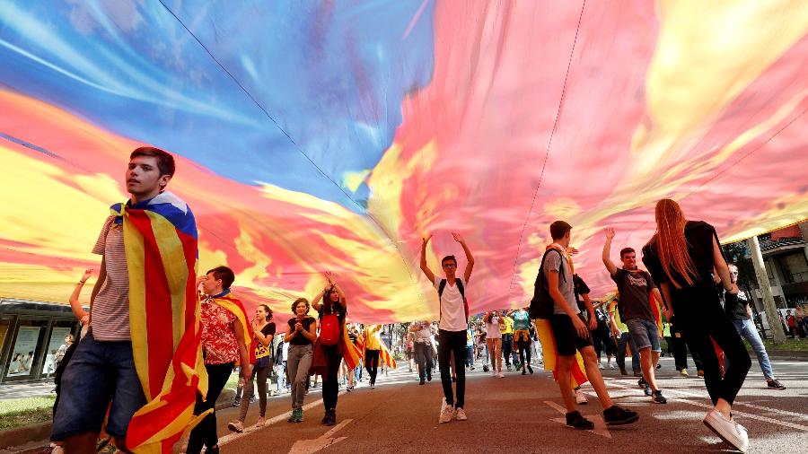 16.dez.2019 - Manifestantes em Barcelona caminham sob a bandeira catalã separatista, em outubro, durante a greve geral da Catalunha - Albert Gea/Reuters