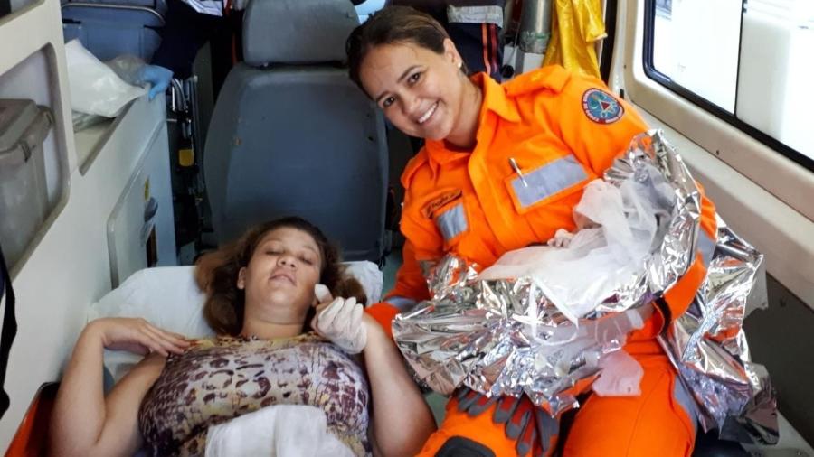 A aspirante do Corpo de Bombeiros Andresa Vicente Amante segura o bebê Lara após parto feito em estação de ônibus em BH - Divulgação/Corpo de Bombeiros MG