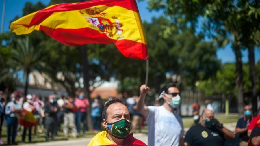 30.mai.2020 - De máscara e enrolado em uma bandeira, homem participa de marcha de apoio à Guarda Civil da Espanha, em Málaga - Jesus Merida/SOPA Images/LightRocket via Getty Images