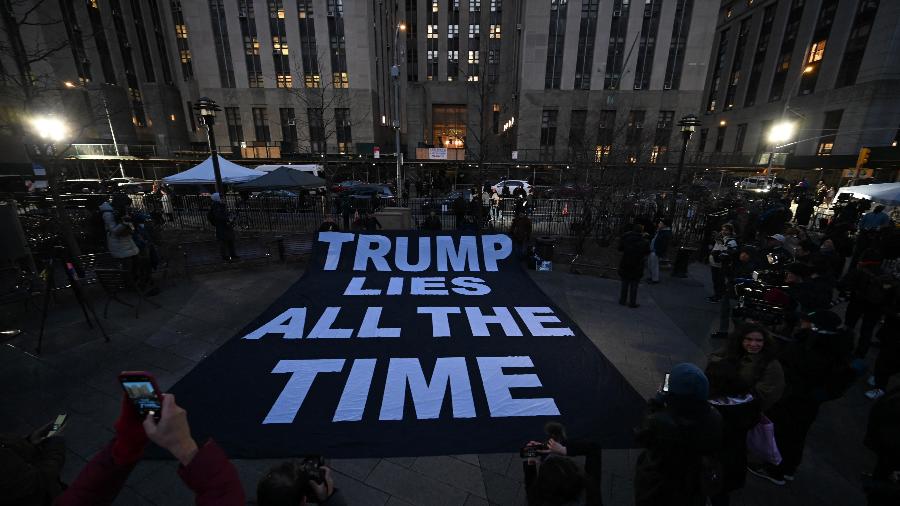 30.mar.2023 - Uma faixa com a frase "Trump mente o tempo todo" é exibida na calçada em frente ao gabinete da Procuradoria de Manhattan, Nova York (EUA) - Ed Jones/AFP