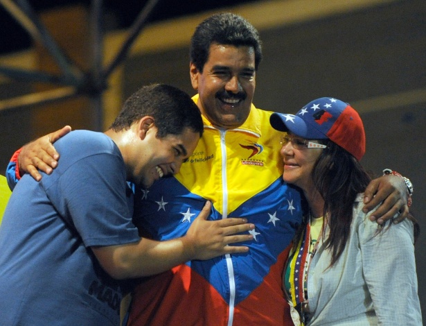 O presidente Nicolás Maduro (centro) abraça sua mulher Cilia Flores e seu filho Nicolas Ernesto Maduro Guerra, o "Nicolasito" - Juan Barreto/ AFP