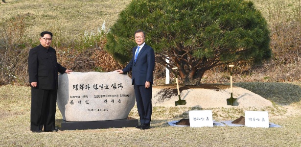 27.abr.2018 - O líder Kim Jong-Un, da Coreia do Norte, e o presidente Moon Jae-In, da Coreia do Sul, posam em frente a pedra com a inscrição: "A paz e a prosperidade foram plantadas" - Korea Summit Press Pool