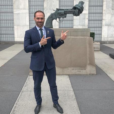 Eduardo Bolsonaro posa fazendo "arminha" em frente a escultura pela paz - Reprodução/Instagram