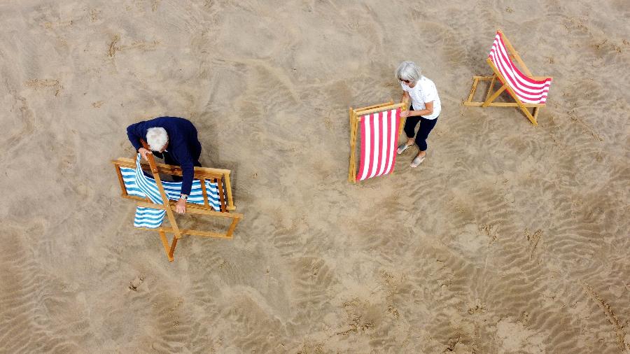 Casal abre cadeiras na areia em praia no Reino Unido; país vive onda de calor - Phil Noble/Reuters 
