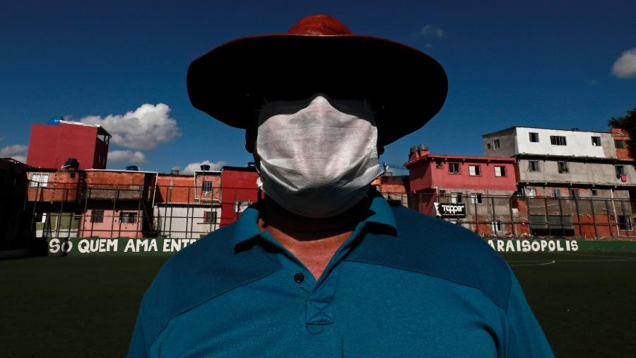 Homem voluntário usa máscara contra coronavírus em Paraisópolis (São Paulo) - Por Stephen Eisenhammer