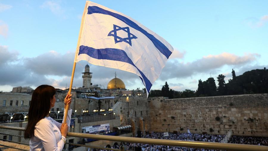 Mulher segura bandeira de Israel com a Estrela de Davi 