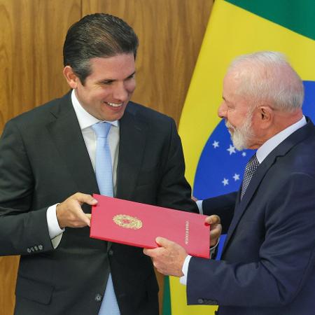 O presidente da Câmara, Hugo Motta, sorri com Lula