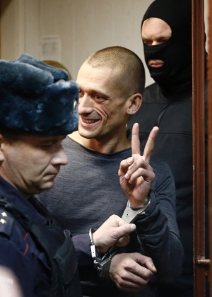 O polêmico artista russo Piotr Pavlenski (centro) é detido após atear fogo à sede do serviço secreto russo, em Moscou