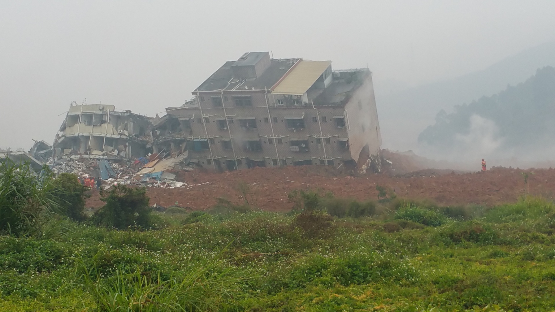 20.dez.2015 - Edifício é atingido por deslizamento de terra que sepultou um parque industrial em Shenzhen, província de Guangdong (China). O desastre atingiu uma área de mais de 100 mil metros quadrados - Bai Yu/Xinhua