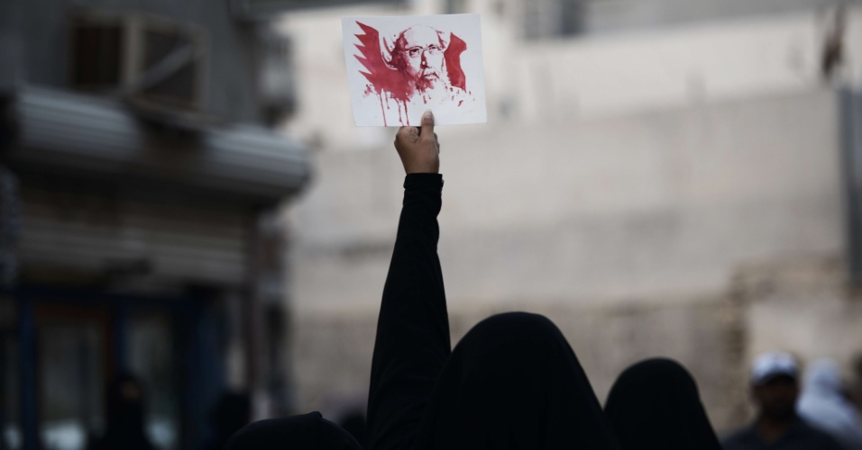 JANEIRO: AS CONSEQUÊNCIAS DA EXECUÇÃO DO CLÉRIGO XIITA SAUDITA - Uma mulher barenita segura o retrato do popular clérigo xiita Nimr al-Nimr para protestar contra sua execução na Arábia Saudita. Al-Nimr, crítico da monarquia sunita e defensor da minoria xiita daquele país, foi executado em 2 de janeiro com outros 46 homens, a maioria ligada à Al Qaeda e condenada por acusações de terrorismo. As relações entre os árabes e o Irã, de maioria xiita, já frágeis porque os dois países defendiam lados opostos nos conflitos no Iêmen e na Síria, se dissolveram completamente após a execução, complicando ainda mais os esforços para levar a paz à região