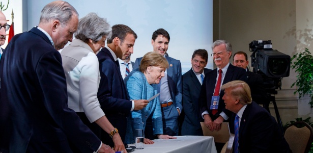 A primeira-ministra da Alemanha, Angela Merkel, e o presidente dos EUA, Donald Trump, se encaram rodeados de líderes do G7, em reunião realizada em Quebec (Canadá) - Adam Scotti/Prime Minister"s Office/Handout via REUTERS