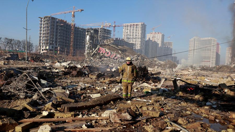 21.mar.2022 - Socorrista em local de shopping bombardeado no distrito de Podilskyi, em Kiev - REUTERS/Serhii Nuzhnenko