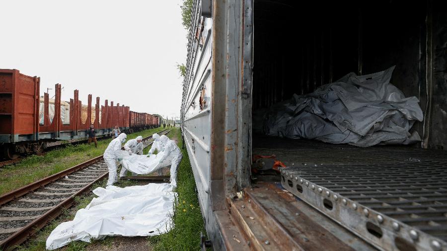 13.mai.2022 - Militares ucranianos carregam corpos de soldados russos em vagões refrigerados. - REUTERS/Valentyn Ogirenko